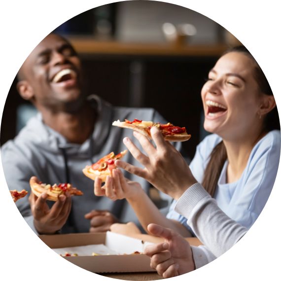 people laughing and enjoying a delivered pizza